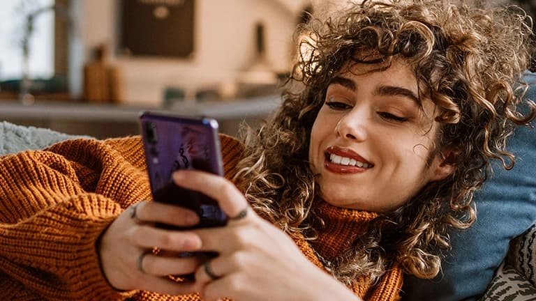 Een vrouw gebruikt haar telefoon om online zorg te regelen