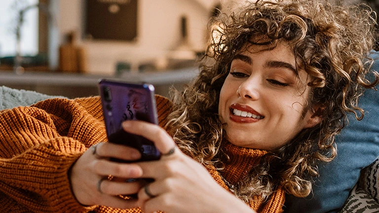 Een vrouw gebruikt haar telefoon om online zorg te regelen